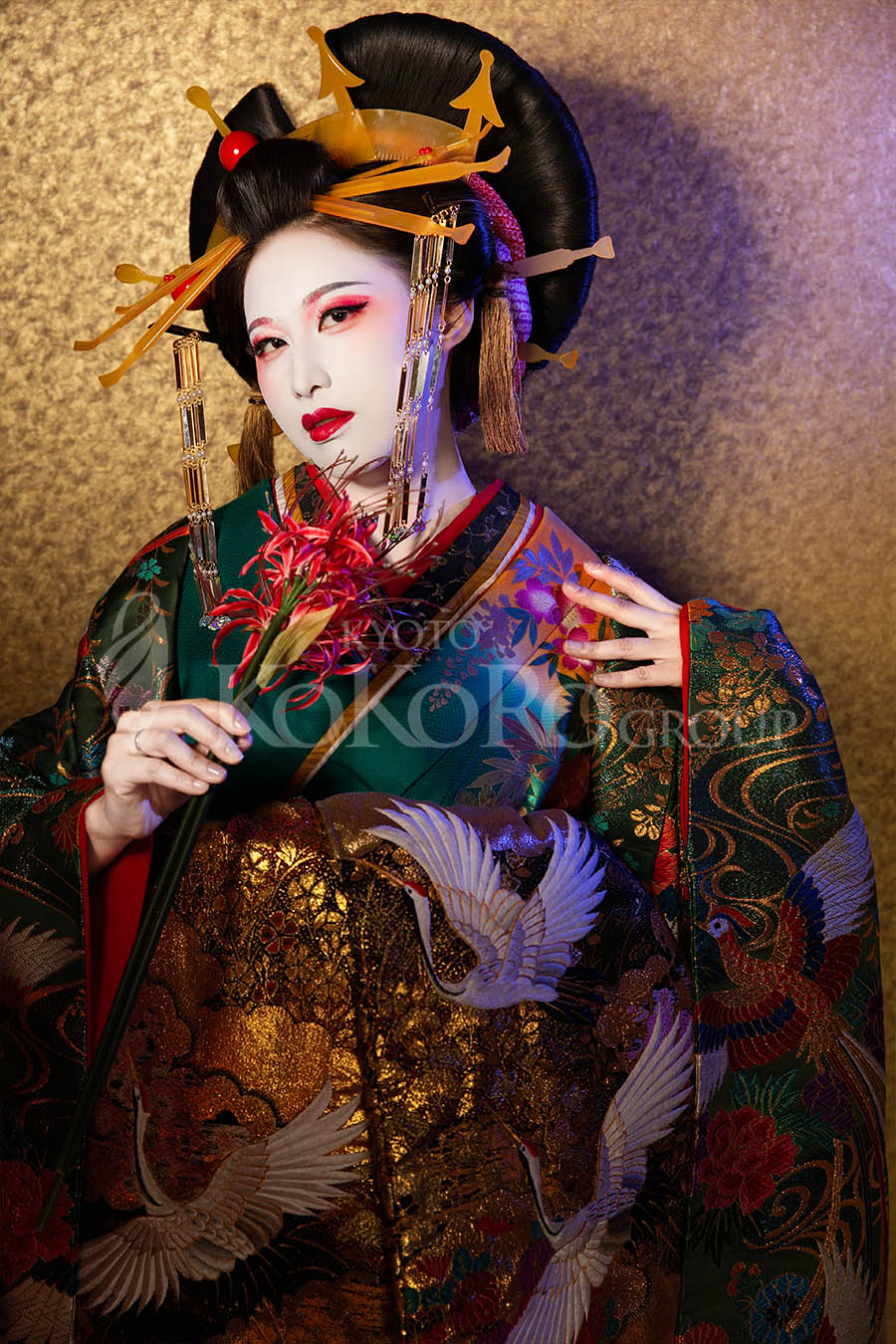 White powder oiran makeup with deep green kimono and gold leaf background in Kyoto